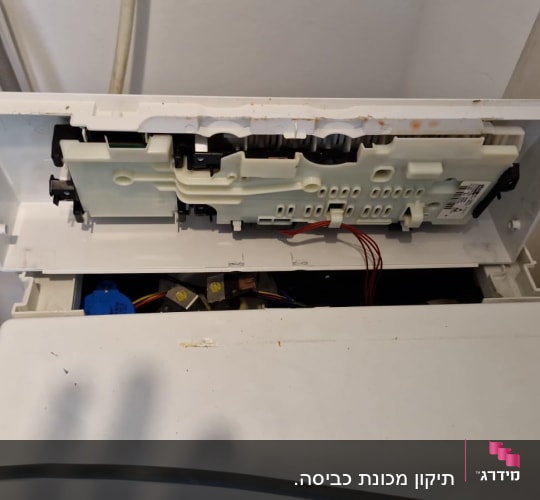 חלקים פנימיים של מכונת כביסה עם חוטים חשמליים